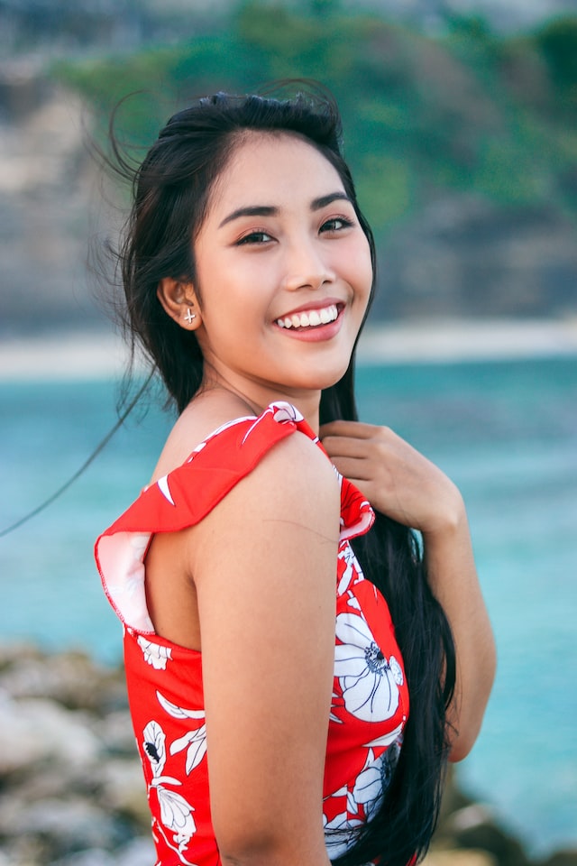 A smiling lady wearing a red top or dress